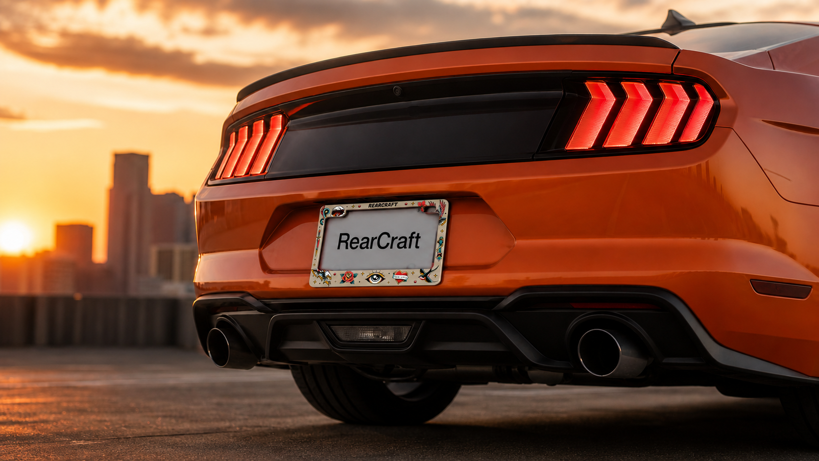 RearCraft tattoo frame installed on an orange sports car at sunset